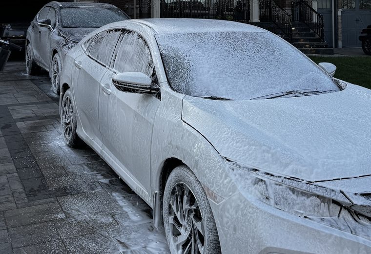 Honda Civic covered in wash foam at dusk