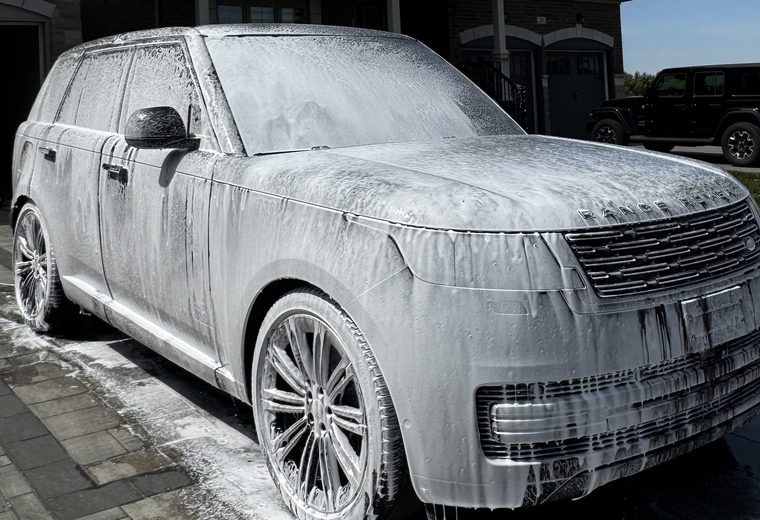 Range Rover covered in snow foam in a driveway